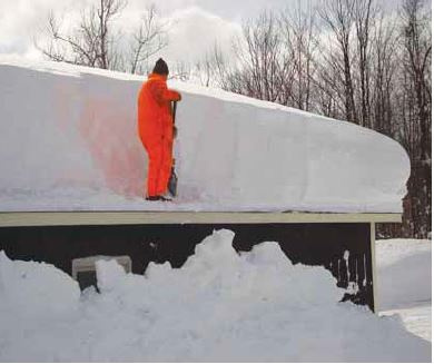 Man shoveling snow off a roof