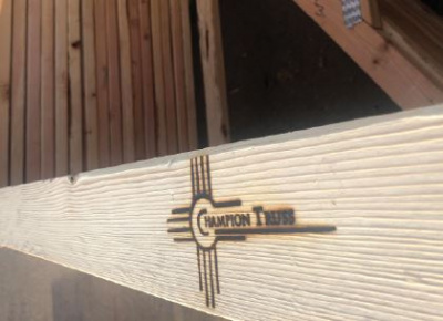 Close up of a Champion Truss wood plank that displays the Champion Truss logo