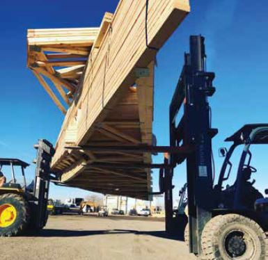 Trusses stacked behind a tractor being transported