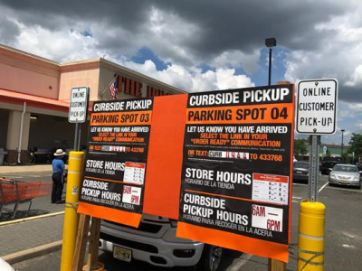 A sign in a Home Depot parking promotes curbside pickup.