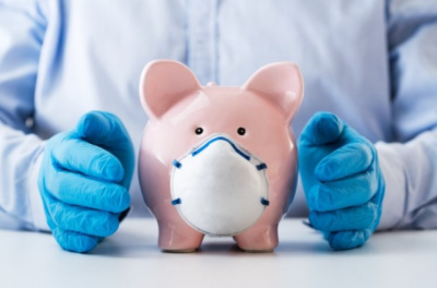A piggy bank wearing a mask with two gloved hands on both sides