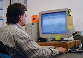 A picture from 1996 of a truss designer sitting at a computer