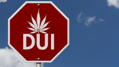 Stop sign with a marijuana leaf and text DUI